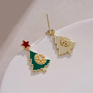 Macro view of gold plated Christmas tree earrings with green oil and clear rhinestones