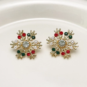 Macro detail of snowflake earrings with colorful rhinestones and white pearls