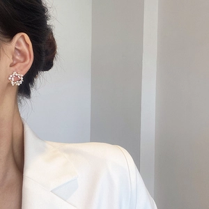 Boucles d'oreilles couronne de perles dorées et strass portées par un mannequin