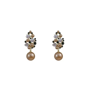 Vintage style gold floral earrings with pearls and black rhinestones on white background
