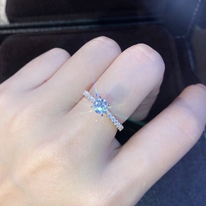 Dettaglio macro di un anello con zircone rotondo brillante e fascia in micro-pavé al dito