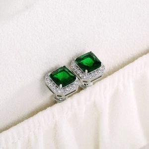 Detail of square green zircon stud earrings with silver-white metal and pavé micro-diamonds