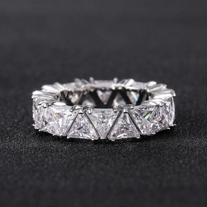 Macro shot of triangle-cut eternity ring with silver claw settings and sparkling stones