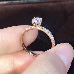 Dettaglio laterale di un anello in oro rosa con zircone tondo e pavé di piccoli diamanti
