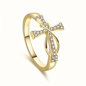 Makroaufnahme von Goldring mit Zirkonia-Kreuz und polierter Oberfläche