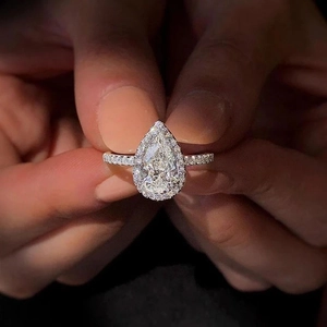 Elegant pear-cut halo engagement ring with pavé diamonds on a white gold band