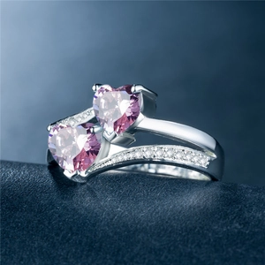 Makroaufnahme Silberring mit zwei herzförmigen rosa Zirkonia und seitlichem Pavé-Besatz