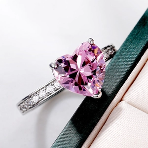 Macro shot of heart-shaped pink zircon engagement ring with side row diamonds