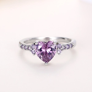 Detailed view of a silver heart ring featuring a large purple gemstone and side accents