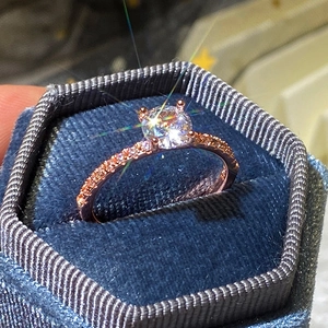 Dettaglio dell'anello di fidanzamento in oro rosa con zircone in una scatola blu