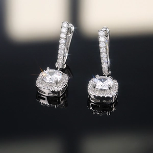 Detailed close-up of square halo drop earrings with zircon inlays and silver finish