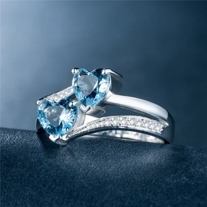 Makroaufnahme des Doppelherz-Rings mit blauen Edelsteinen und Zirkonia-Akzenten