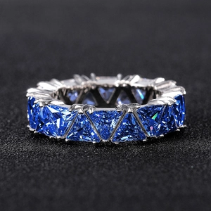 Elegant eternity ring featuring triangular blue zircons set in a silver-tone metal band