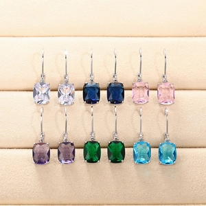 Macro shot of cushion-cut colorful topaz drop earrings set in velvet jewelry tray