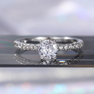 Macro di un anello di fidanzamento con zircone brillante, pietre laterali e riflessi