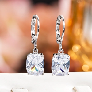 Detailed view of silver lever-back earrings featuring cushion-cut blue faux topaz stones