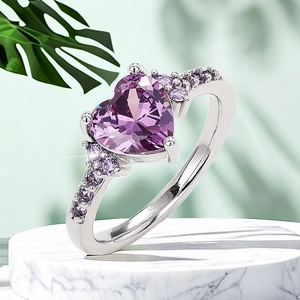 Close-up of elegant heart-shaped purple zircon ring on a marble display stand