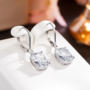 Macro detail of silver lever-back earrings featuring rectangle cut clear zircon stones