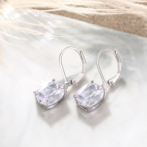 Close-up of cushion-cut blue topaz dangle earrings with silver lever-back clasps