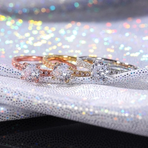 Macro dettagliata di tre anelli di fidanzamento con zirconi in oro rosa, oro e argento
