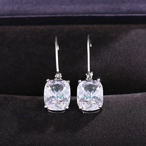 Macro detail of cushion-cut blue topaz earrings with secure French hook in jewelry box
