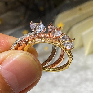 Vista macro dettagliata di anelli in zircone a cuore in argento, oro rosa e finiture oro