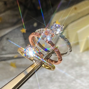 Vista dettagliata di tre anelli di fidanzamento in oro, oro rosa e argento con zirconi