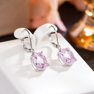 Close-up of cushion-cut pink gemstone leverback earrings on a white leather stand