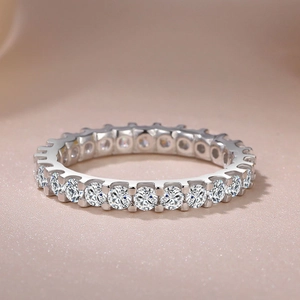 Macro shot of silver eternity ring featuring a full circle of sparkling round-cut diamonds