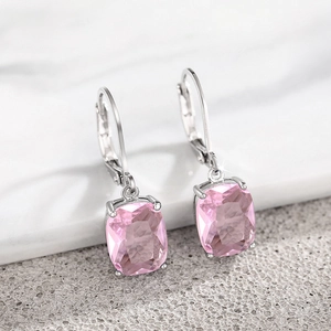 Detail view of pink rectangular zircon drop earrings with silver leverback hooks