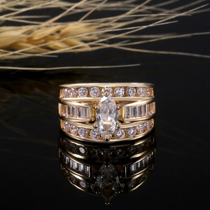 Bague large dorée de luxe avec zircons marquise et baguette sur fond noir élégant