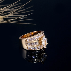Détail d'une bague en zircon marquise sur surface réfléchissante sombre et dorée