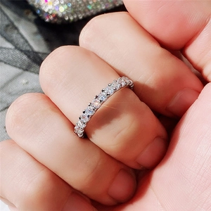 Macro shot of silver eternity ring with sparkling cubic zirconia on finger