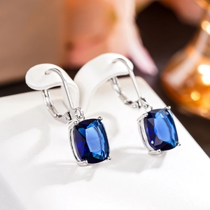 Macro shot of rectangular blue topaz style earrings with silver leverback settings