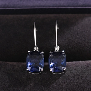 Detail of blue rectangular faceted drop earrings with silver lever-back hooks in a jewelry box