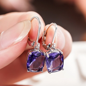 Close-up of cushion-cut purple gemstone drop earrings with silver hooks for women