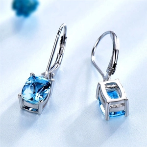 Detailed macro view of lever-back earrings with large rectangular blue topaz stones