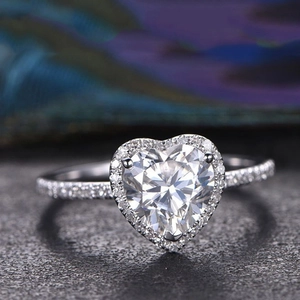 Elegante anello d'argento a cuore con halo di zirconi su fondo di pietra scura