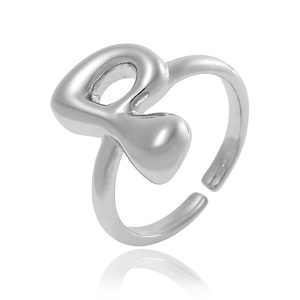 Détail macro d'une bague réglable argentée au design minimaliste en forme de lettre R