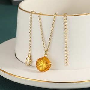 Macro-opname van de goud vergulde schelphanger met emaille afwerking en verstelbare ketting