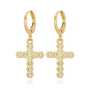 Vue détaillée de boucles d'oreilles croix dorées avec cadres hexagonaux et zircons