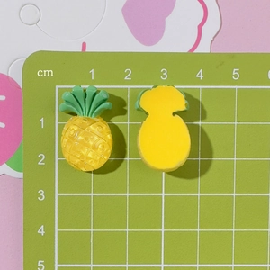 Macro view of 2cm yellow resin pineapple charms for DIY crafts with size scale