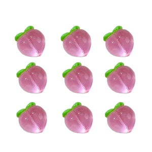 Pink resin peach charms for DIY crafts, 9-piece set with green leaf details on white background