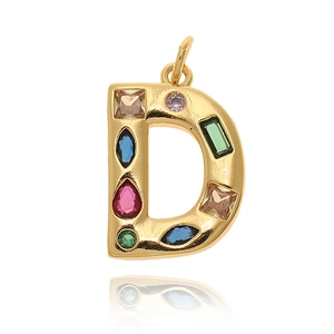 Primer plano detallado de un colgante letra D dorado con circonitas de varios colores