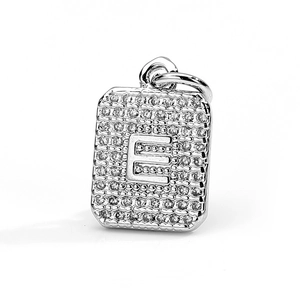 Macro shot of silver letter E pendant featuring cubic zirconia pavé on a square base