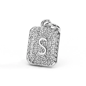 Macro shot of silver-toned rectangular pendant with pave-set cubic zirconia and letter S