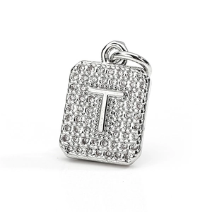 Macro shot of silver-plated rectangular letter T pendant with pavé set zircon stones