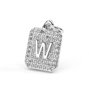 Close-up of rectangular copper pendant with zircon pavé and raised letter W detail