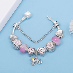 Bracciale di perle di cristallo rosa con ciondoli a cuore e pendente a bici su fondo blu