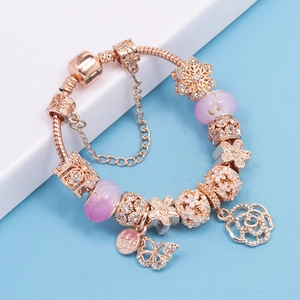 Elegantes rotgoldenes Schlangenarmband mit lila Glasperlen und floralen Anhängern